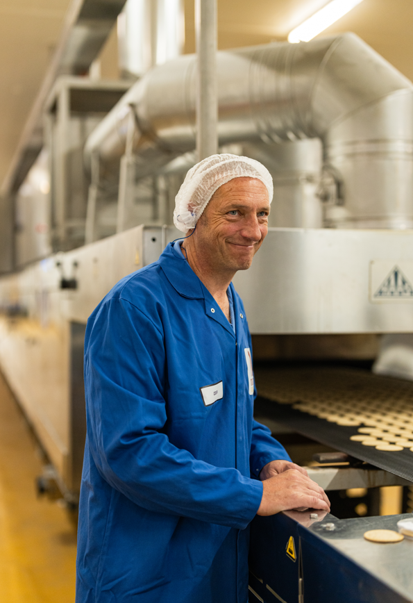 person standing beside a production line