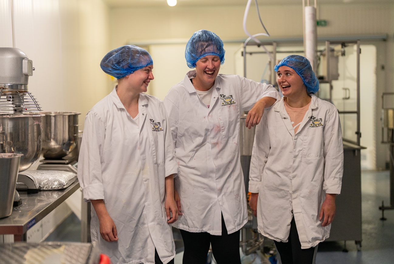 three people laughing together in a factory